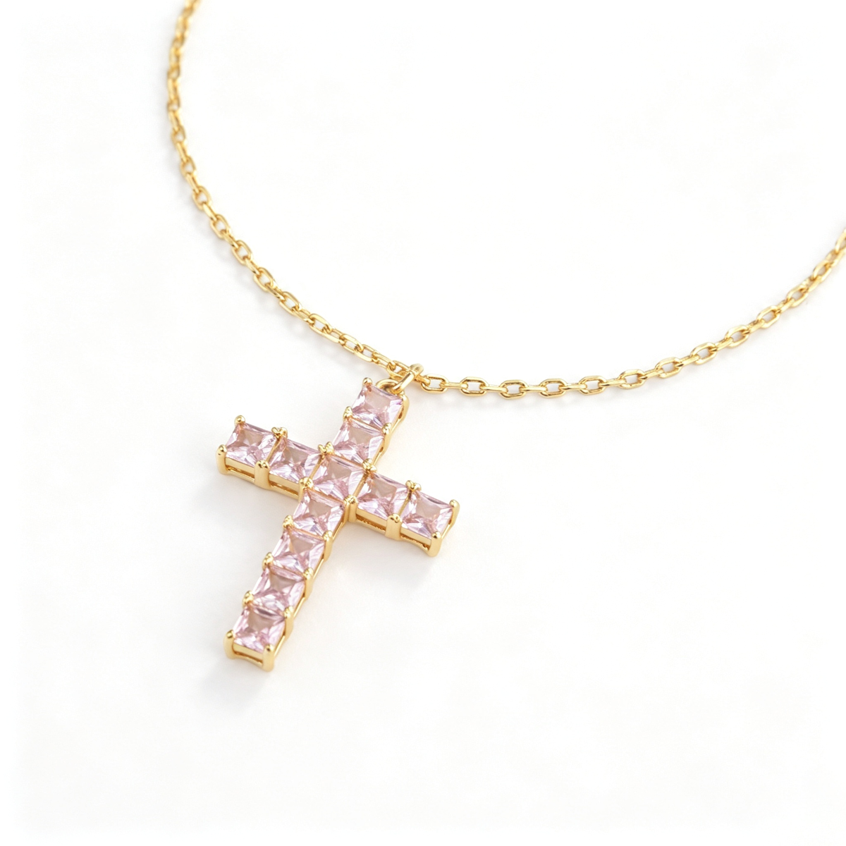 Full view of the cross necklace showing the chain, pendant, and adjustable extension