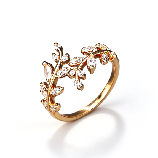 Gold-tone open ring with branching leaf details and clear decorative accents, shown alone on white.