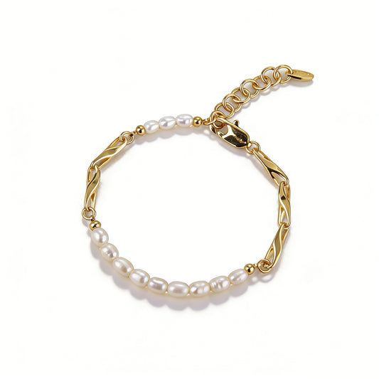 High-angle view of a dainty gold pearl bracelet with minimalist 18k gold plated links and natural oval pearls.