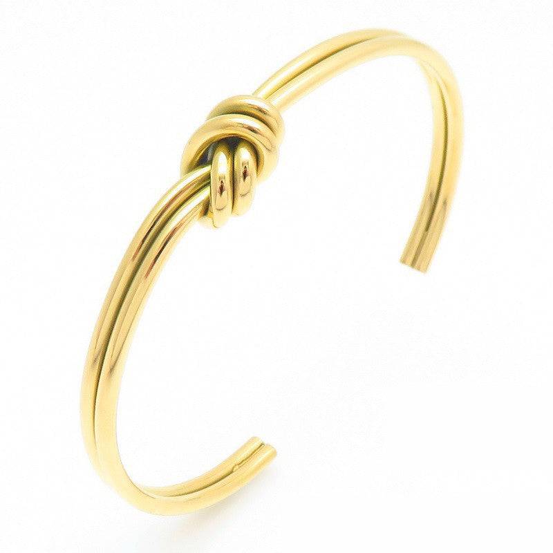 Side profile of the gold double-strand knot cuff showing the open ends