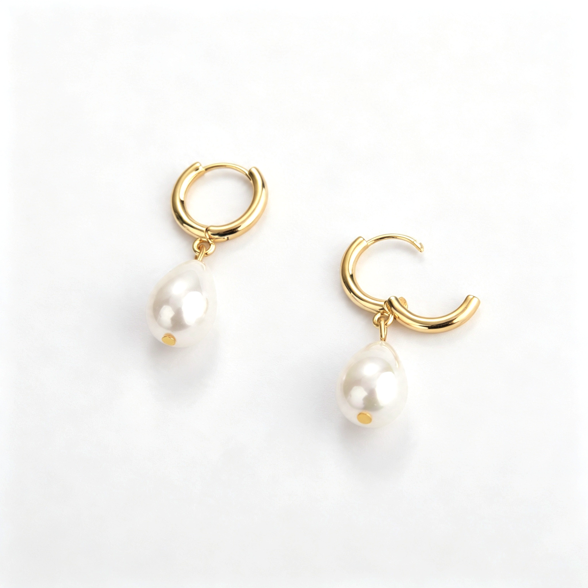 Paired drop hoop earrings highlighting the teardrop accent silhouette
