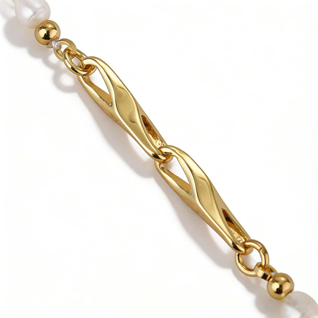 Side view of a delicate pearl charm dropping from a modern 18k gold plated chain, perfect for layering.