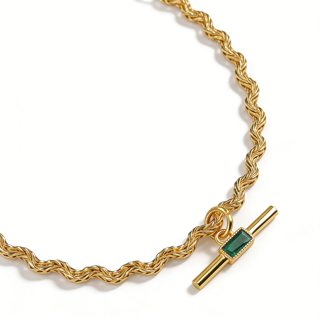 Vintage style emerald cut green crystal necklace with a four-prong gold setting.
