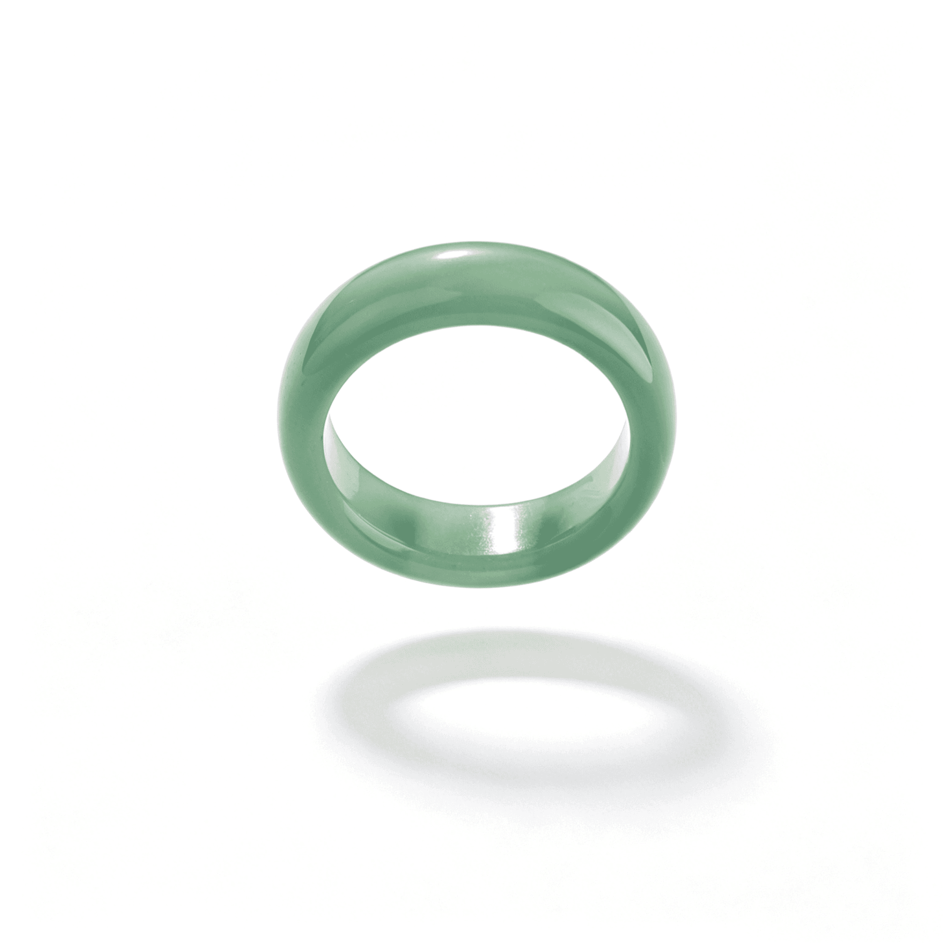 Close-up of a single translucent emerald green chalcedony ring, highlighting its smooth, hand-polished finish and natural stone texture.