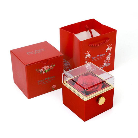 Red rotating rose jewelry box with clear lid, matching gift box and red shopping bag.