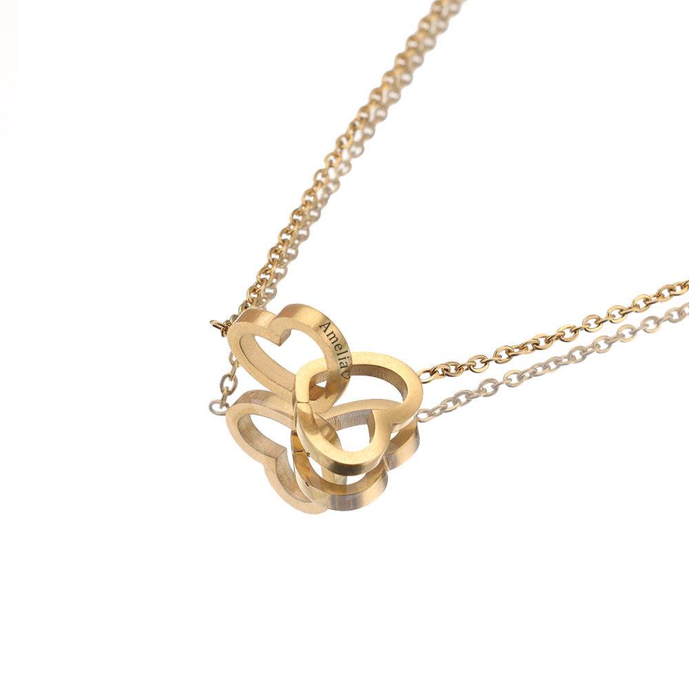 Rose-gold-tone engraved double heart necklace hanging against a white background.