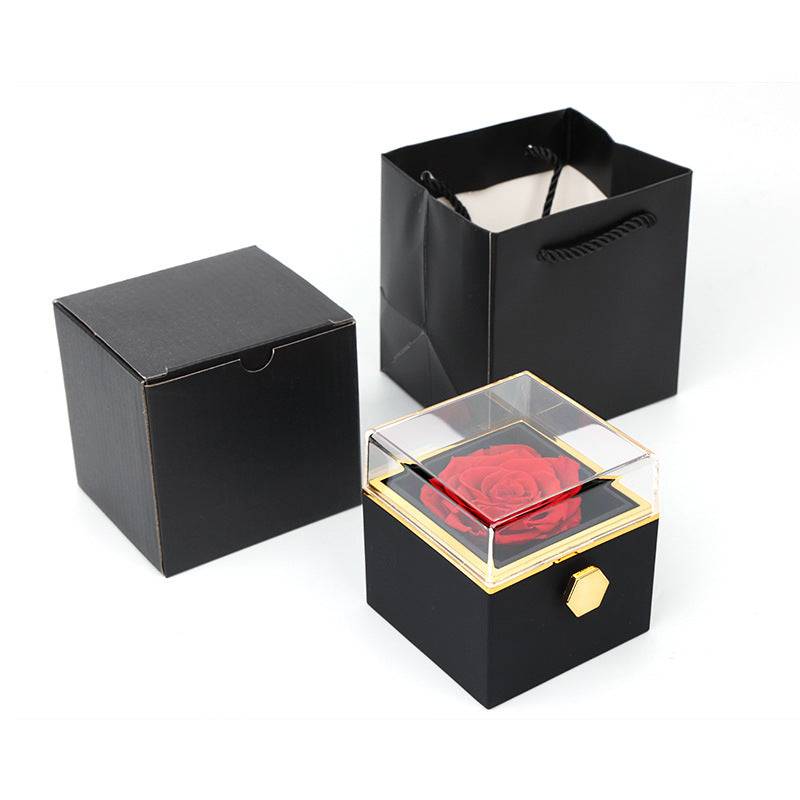 Black rotating rose jewelry box with clear lid and red rose, shown with matching packaging.