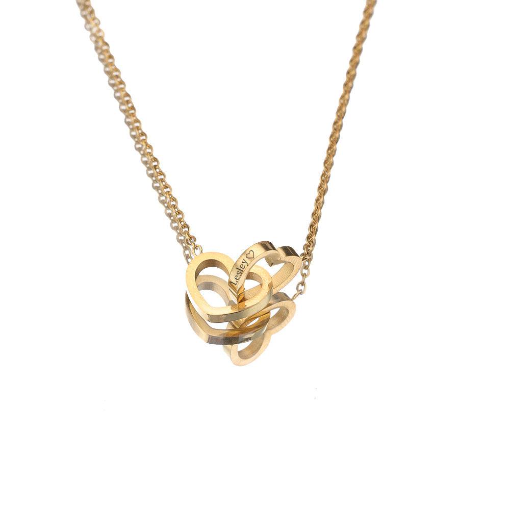 Gold-tone engraved double heart necklace hanging against a white background.