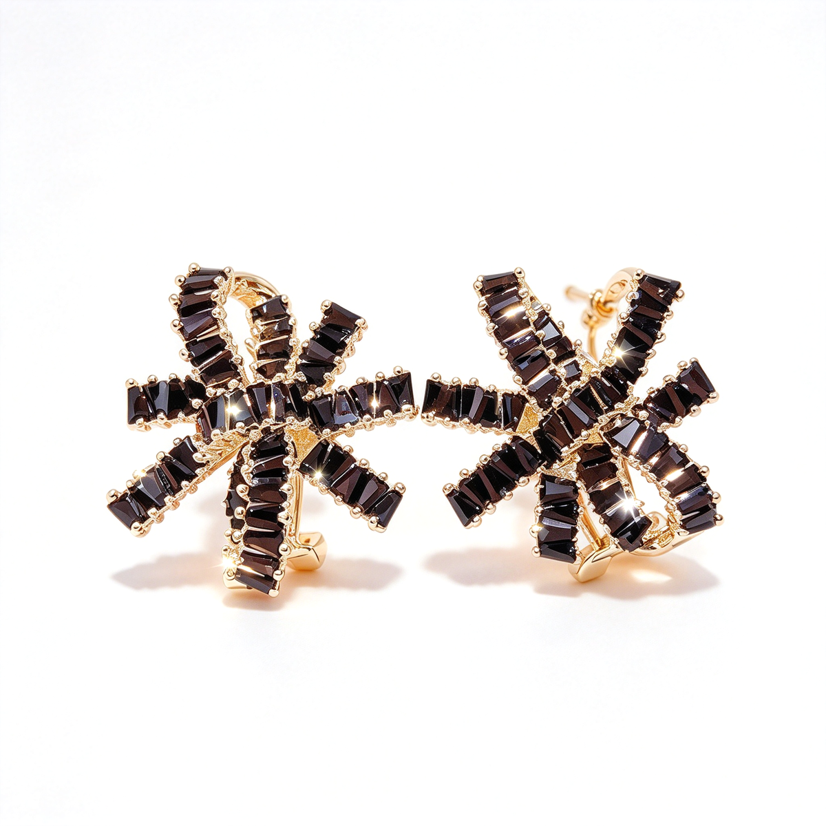 A pair of dark bow knot statement earrings with layered, radiating details displayed on a white background.