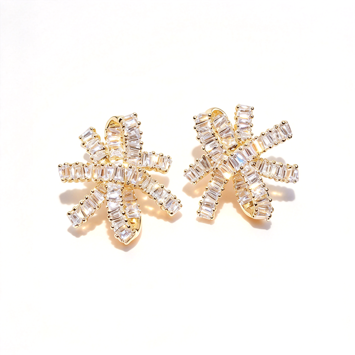 Gold-tone bow knot earrings displayed as a pair, showing the sculpted loops and sparkling decorative details.