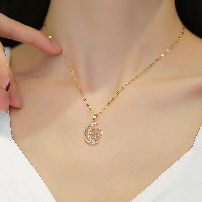 Crescent moon and heart pendant necklace worn at the neckline, showing how the delicate chain and small pendant sit with a white top.