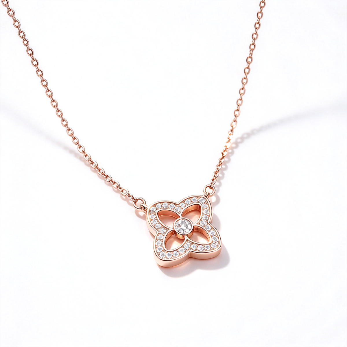 Four-petal flower pendant necklace with a sparkling border and a round center detail on a clean white background.