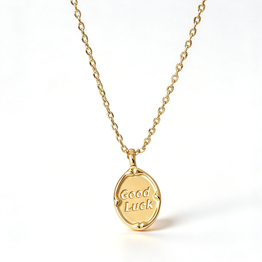 Good Luck pendant necklace with an oval charm displaying engraved lettering, shown against a clean white background.