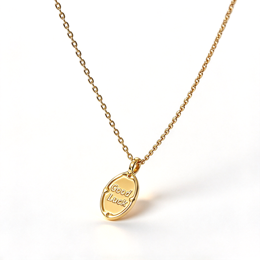 Close-up of the oval pendant showing the Good Luck lettering and decorative border.