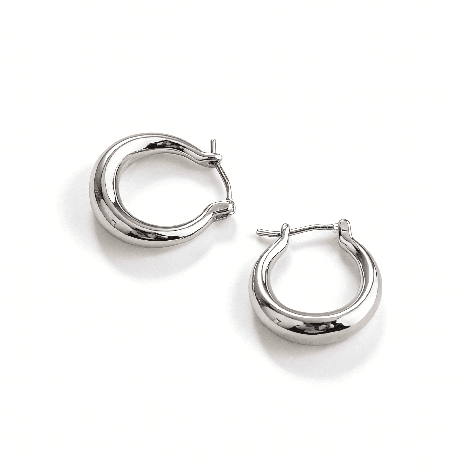 Pair of Ever P. silver hoop earrings featuring a unique liquid-metal molten texture on white background