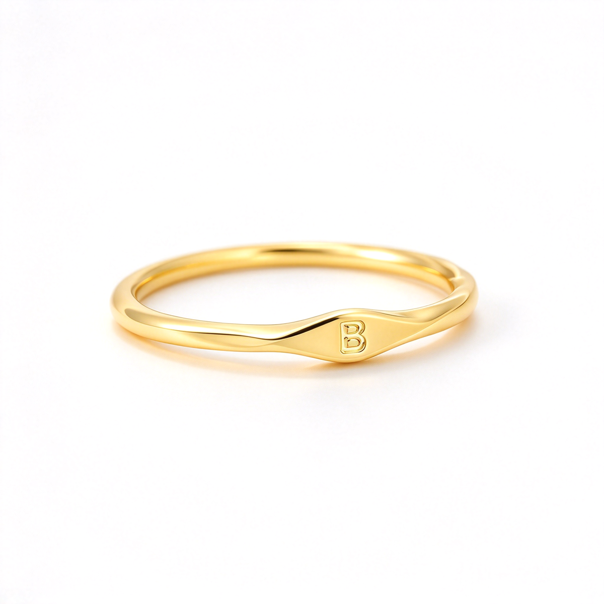 Minimalist initial ring with a slim band and small letter detail, shown on a white background.