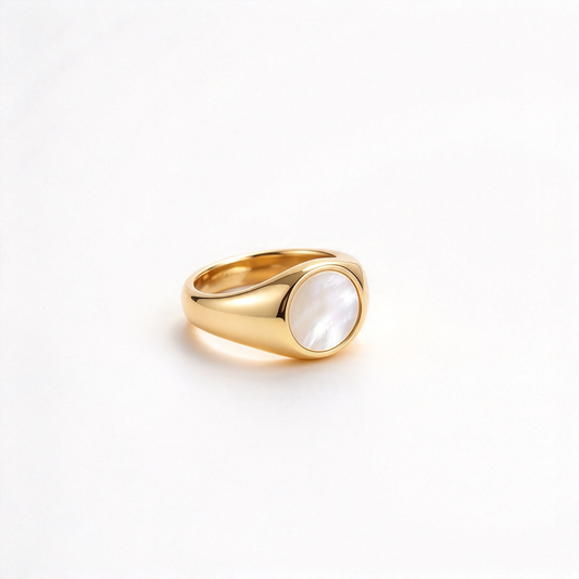 Gold-tone oval ring displayed at a low angle, showing its rounded centerpiece and curved band.