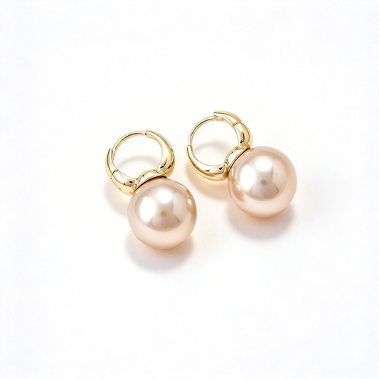 A pair of pearl drop hoop earrings displayed against a clean white background.