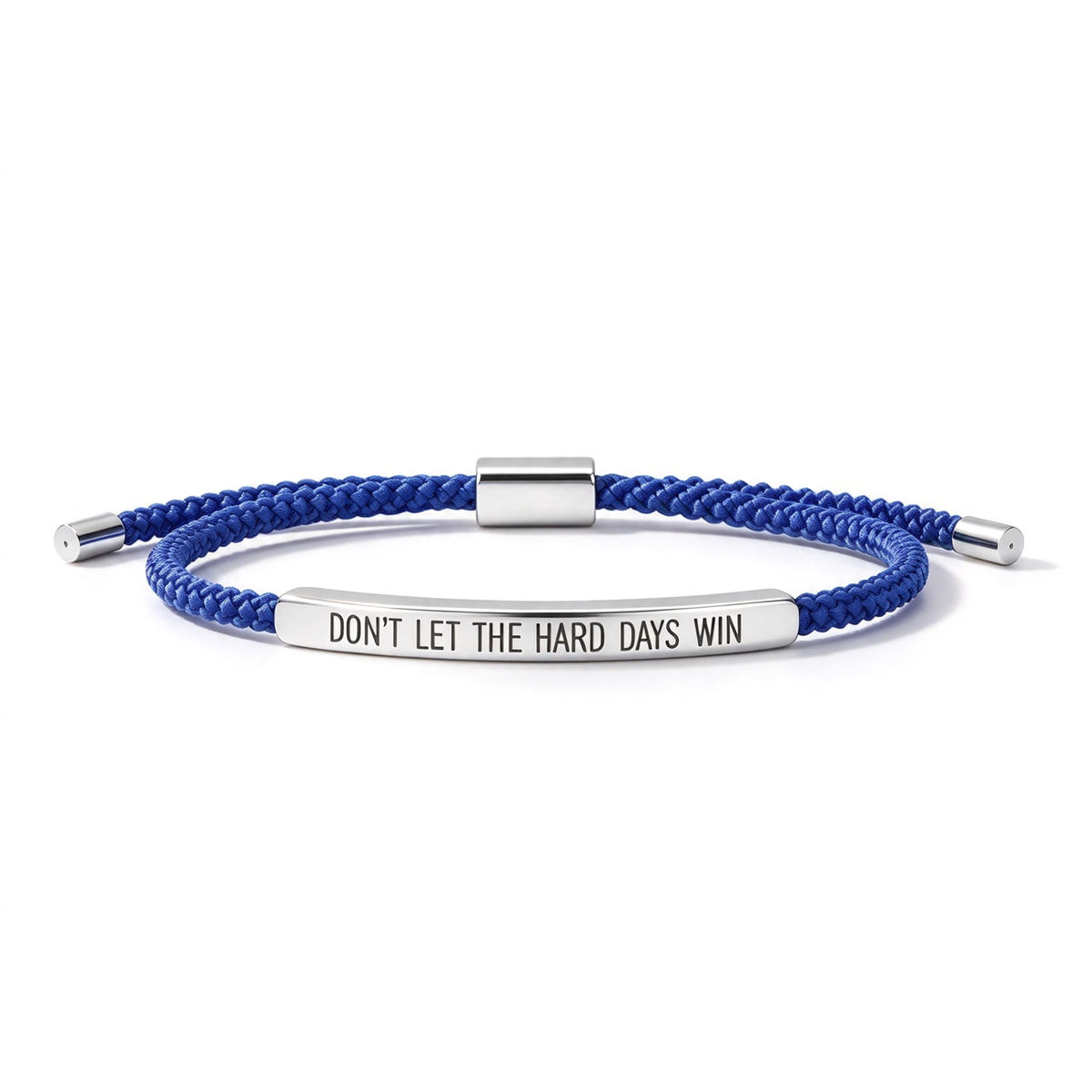 Navy braided cord bracelet with a gold-tone engraved bar displaying “DON’T LET THE HARD DAYS WIN.”