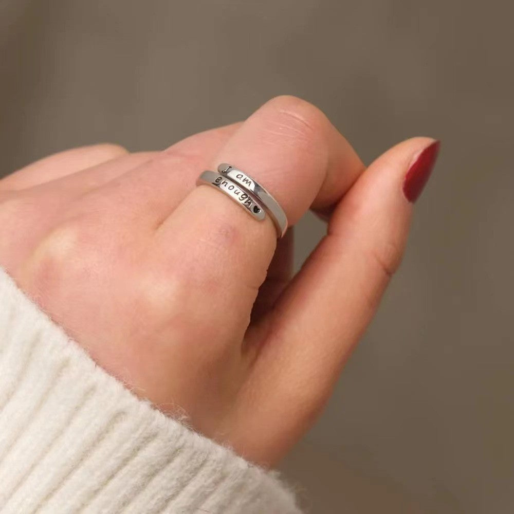 Angled view of the engraved open cuff ring worn on a hand with a cream knit sleeve