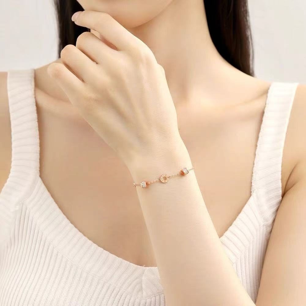 Close-up of a delicate bracelet worn on the wrist, with small circular charms and decorative accents.