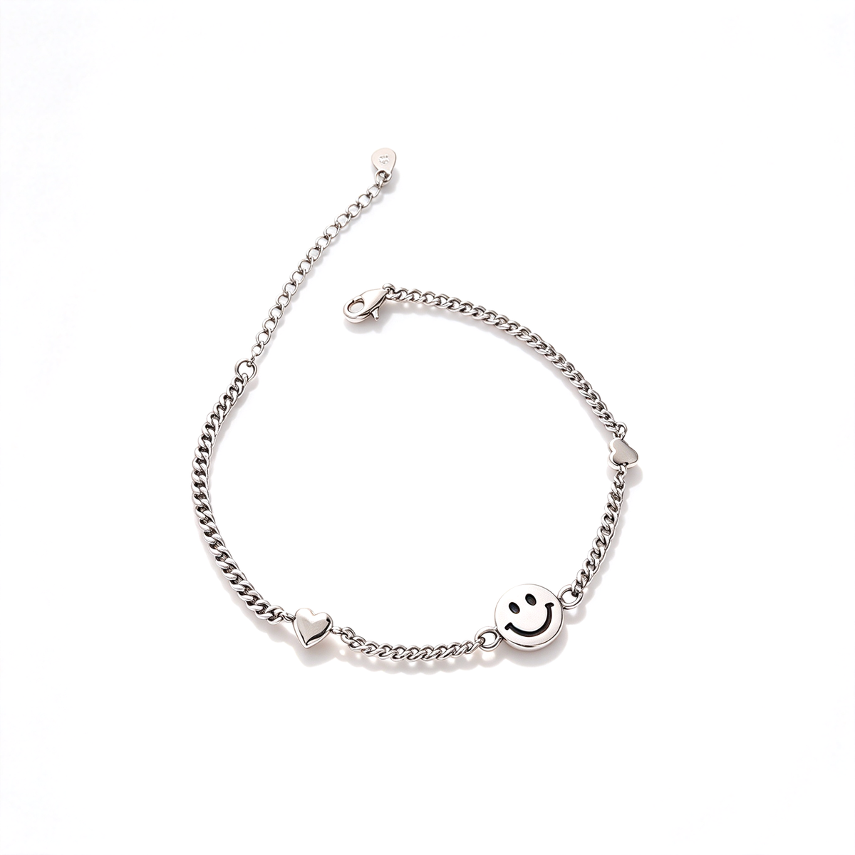 A silver-tone chain bracelet with a round smiley face charm and small heart accents displayed on a white background.