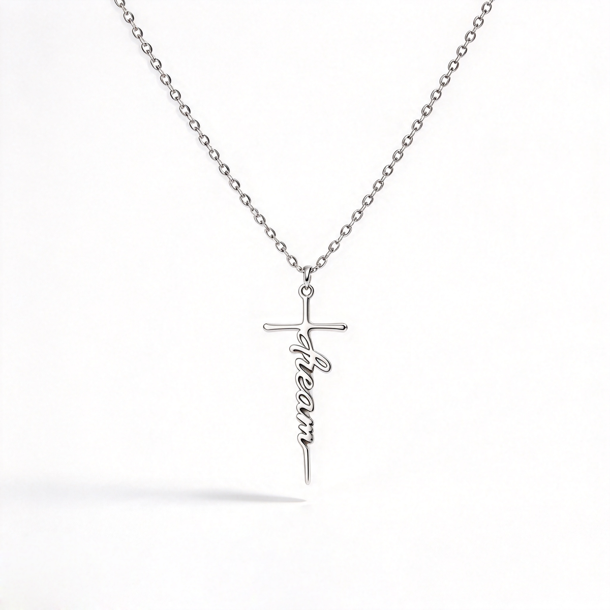 Minimal cross necklace with narrow script lettering centered on a plain white background.