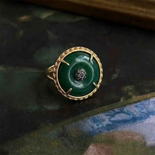 Detailed view of the 18K gold-plated adjustable ring with emerald green stone.