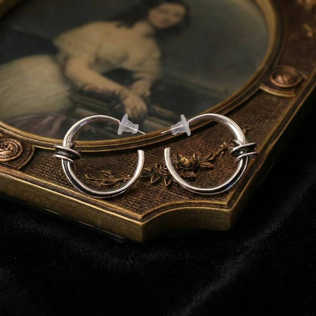 High-definition close-up of a single chunky gold hoop earring with an organic texture finish.