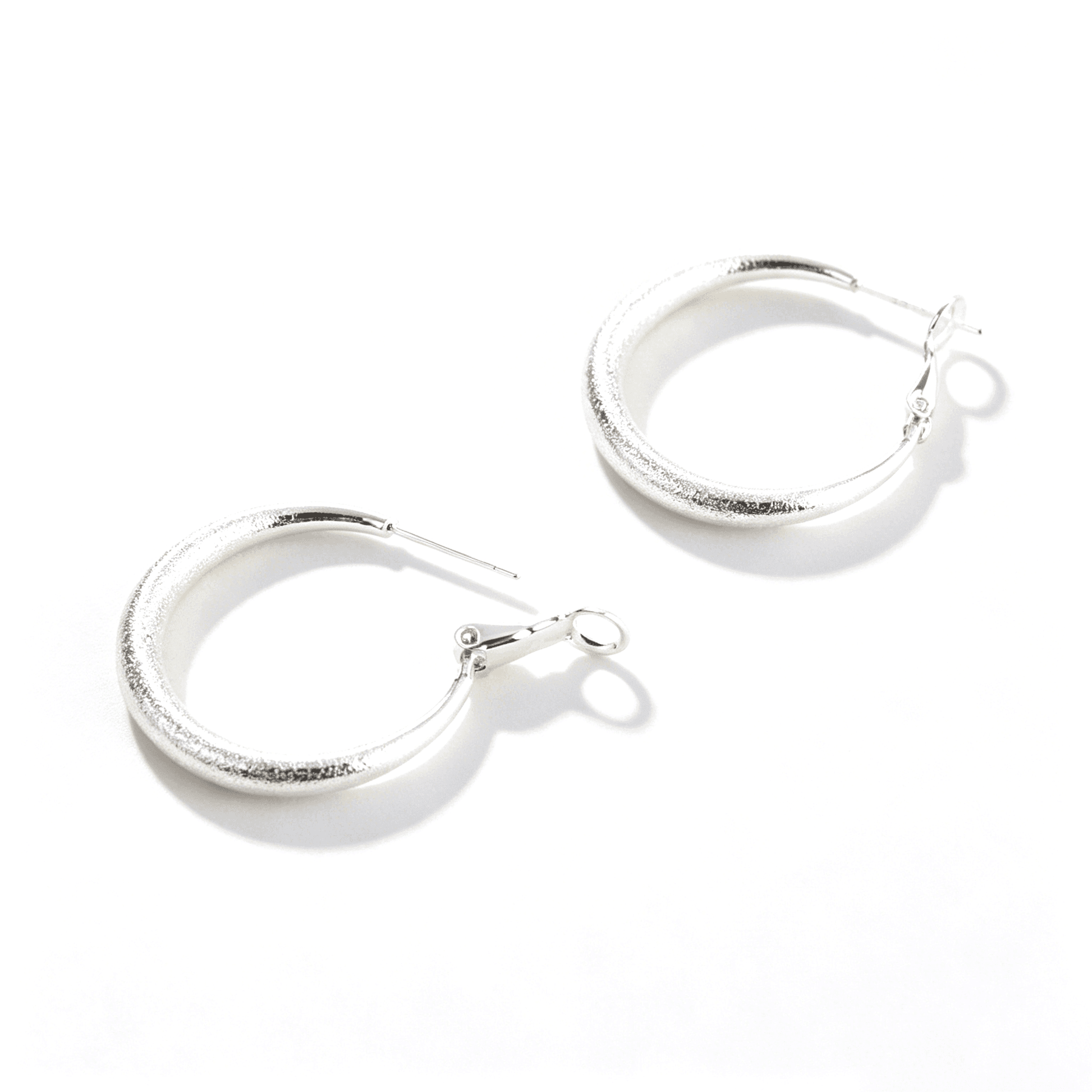 Side view of Ever P. chunky silver hoop earrings, showcasing the thick and smooth tube silhouette.
