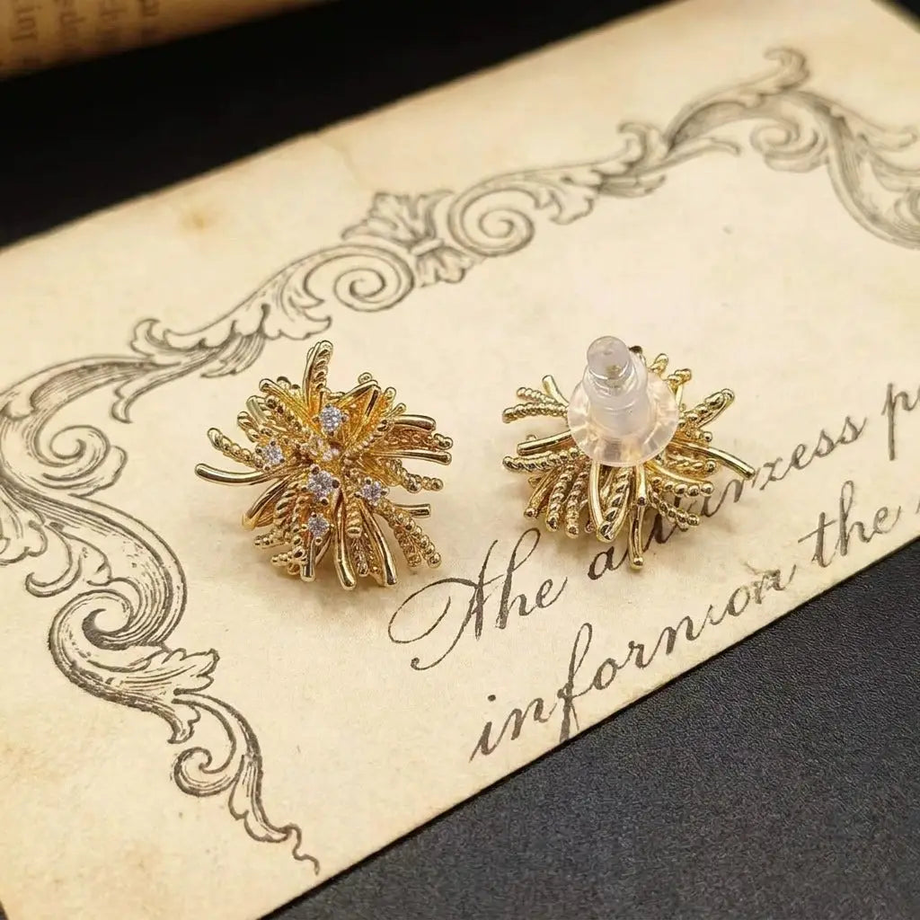 High-definition detail of the 18K gold plated starburst earrings reflecting modern classic luxury.