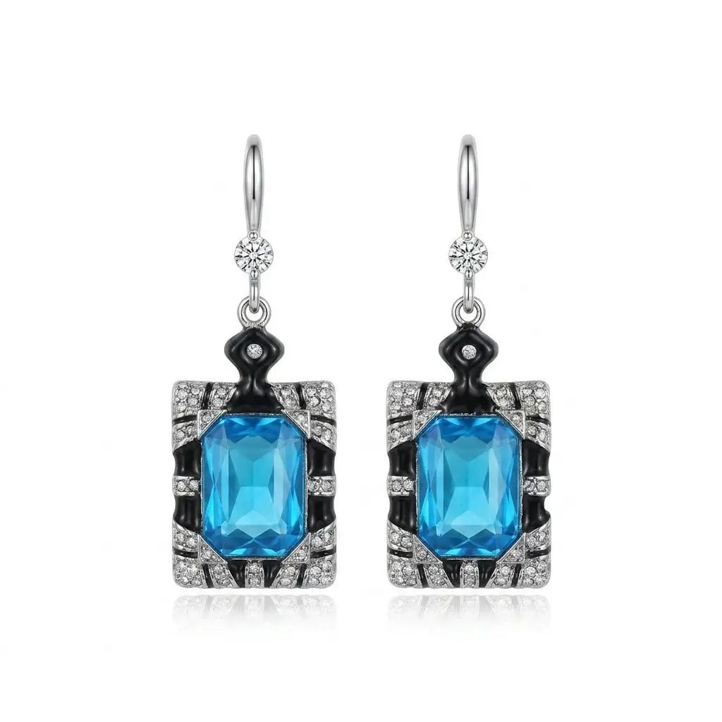 Elegant geometric drop earrings featuring blue aquamarine crystals and white pearls.