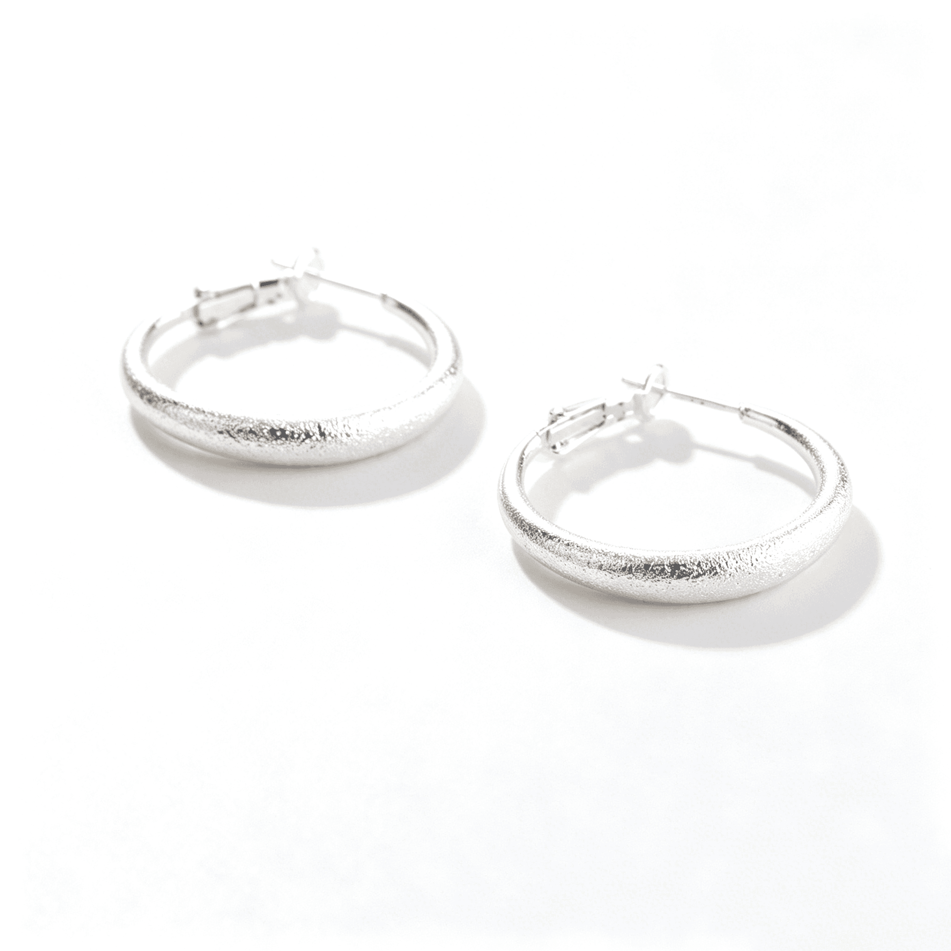 Close-up of the reflective high-polish surface on Ever P. large silver hoops, a perfect statement accessory.