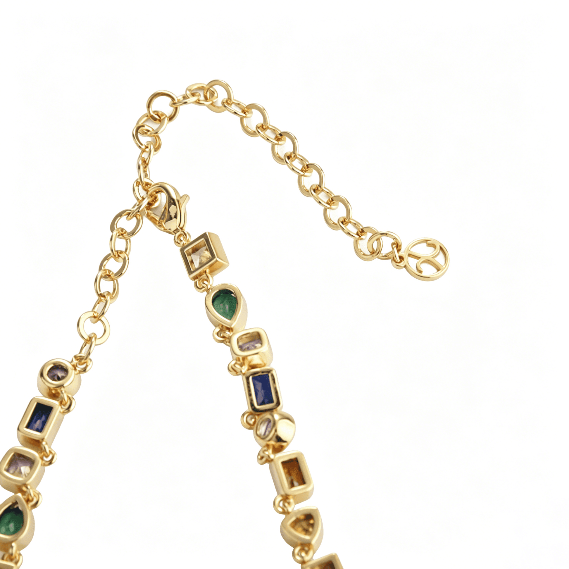 Detailed close-up of the interlocking abstract gold fragments on the colorful gemstone necklace.