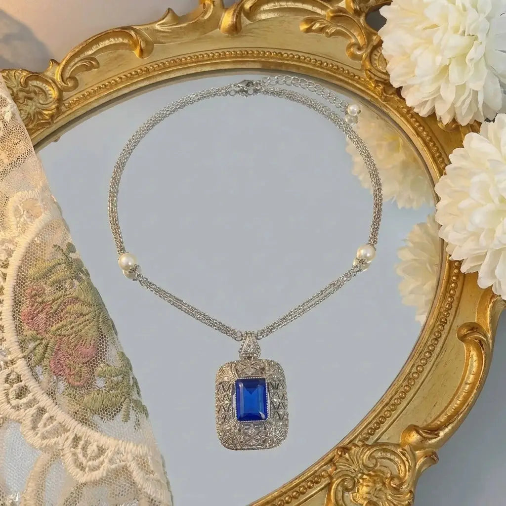 Close-up of the unique knotted chain links on a vintage pearl pendant necklace.