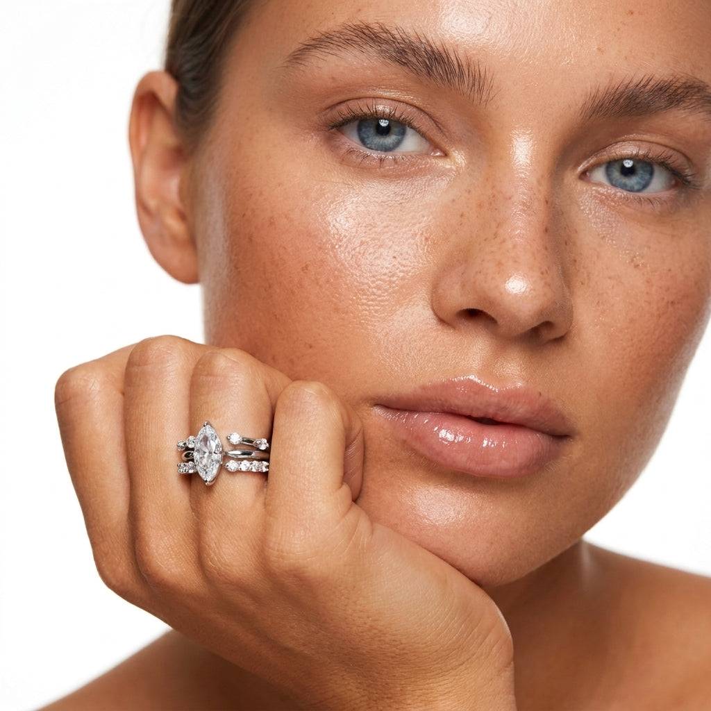 A glamorous shot of an Ever P. 3-in-1 marquise cut ring stack in silver plated copper, worn by a model with freckles.