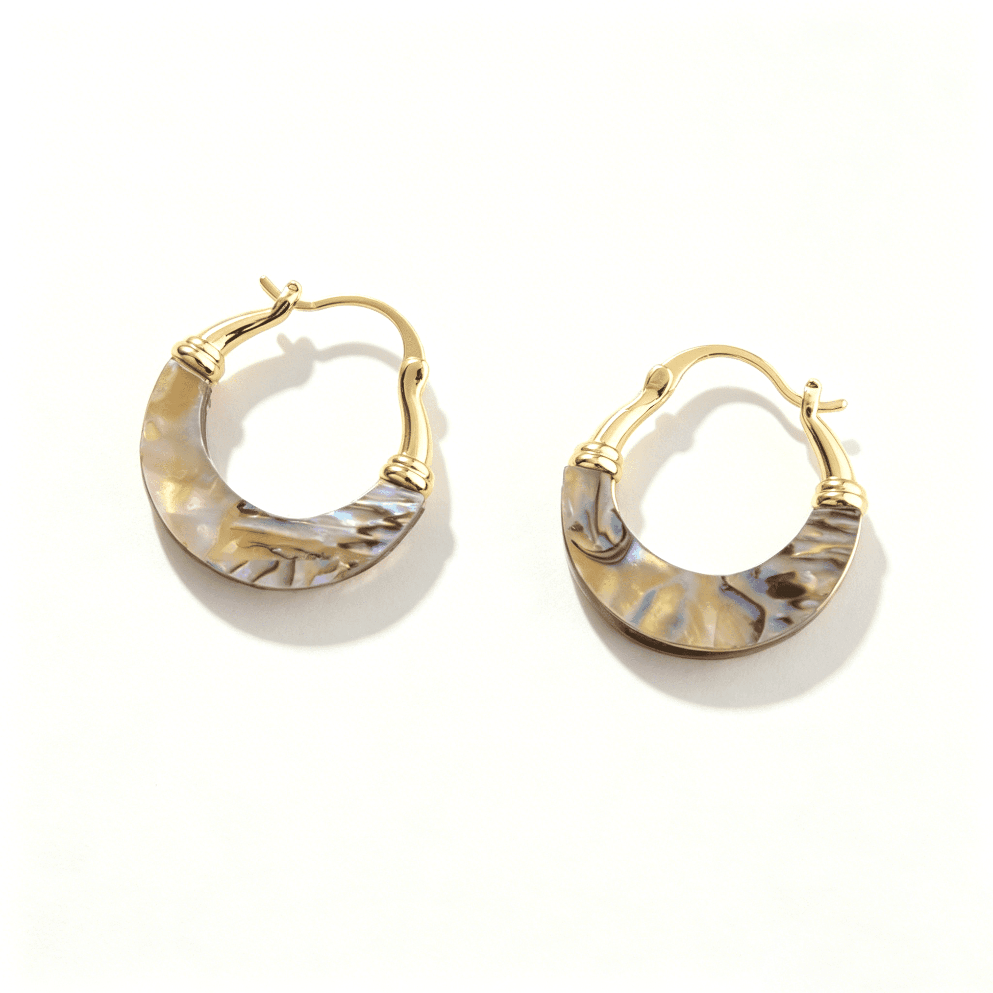 Side view of Ever P. mother of pearl earrings, showcasing the glossy gold-plated finish and natural shell texture.