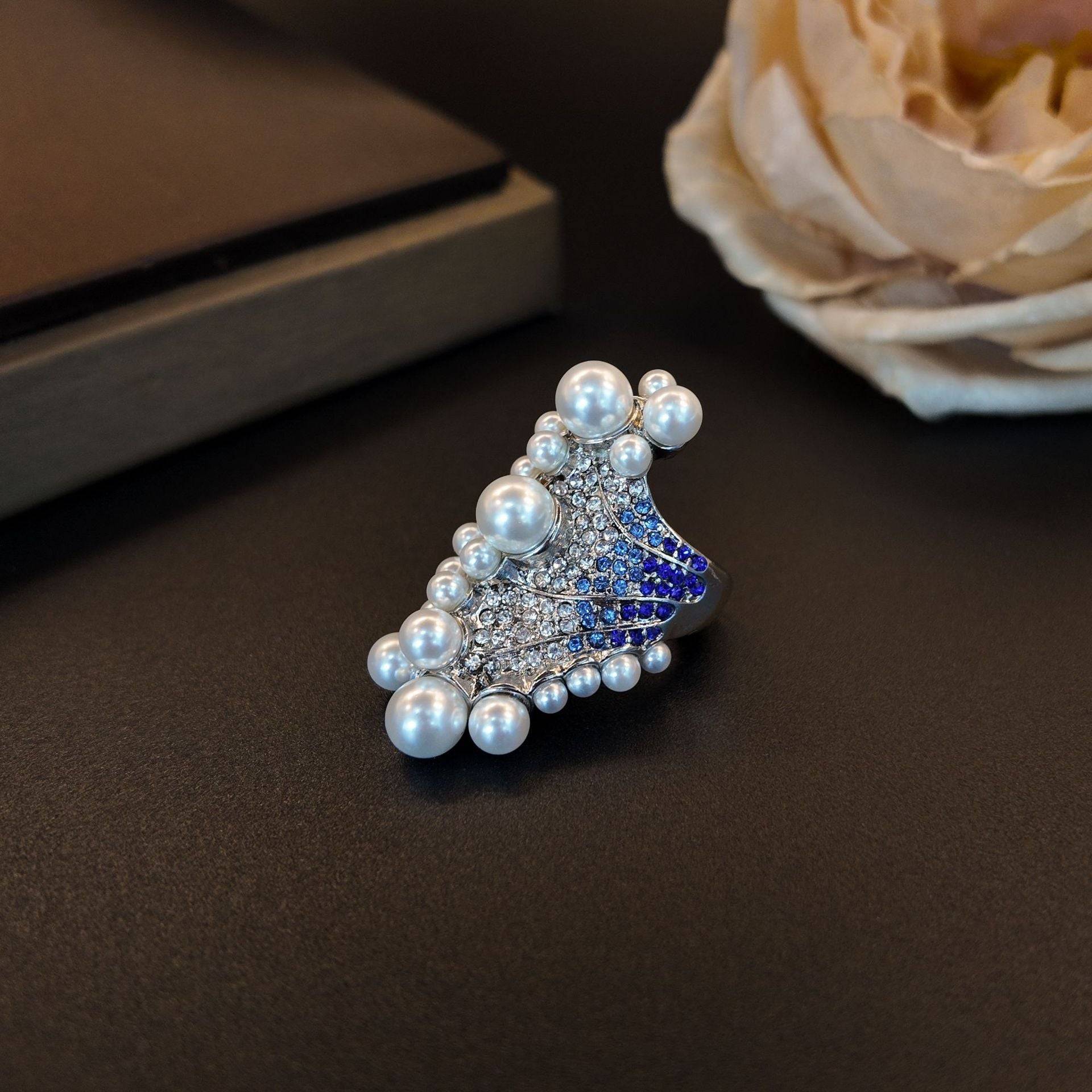 Detailed perspective view focusing on the gradient blue stone ring pavé and sparkling white rhinestones.