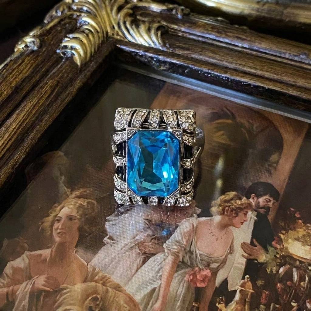 Ever P. old money aesthetic ring featuring deep blue crystal and ornate gold carvings.