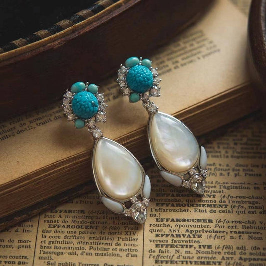 Close-up of the old money jewelry aesthetic with white shell and gold detailing.