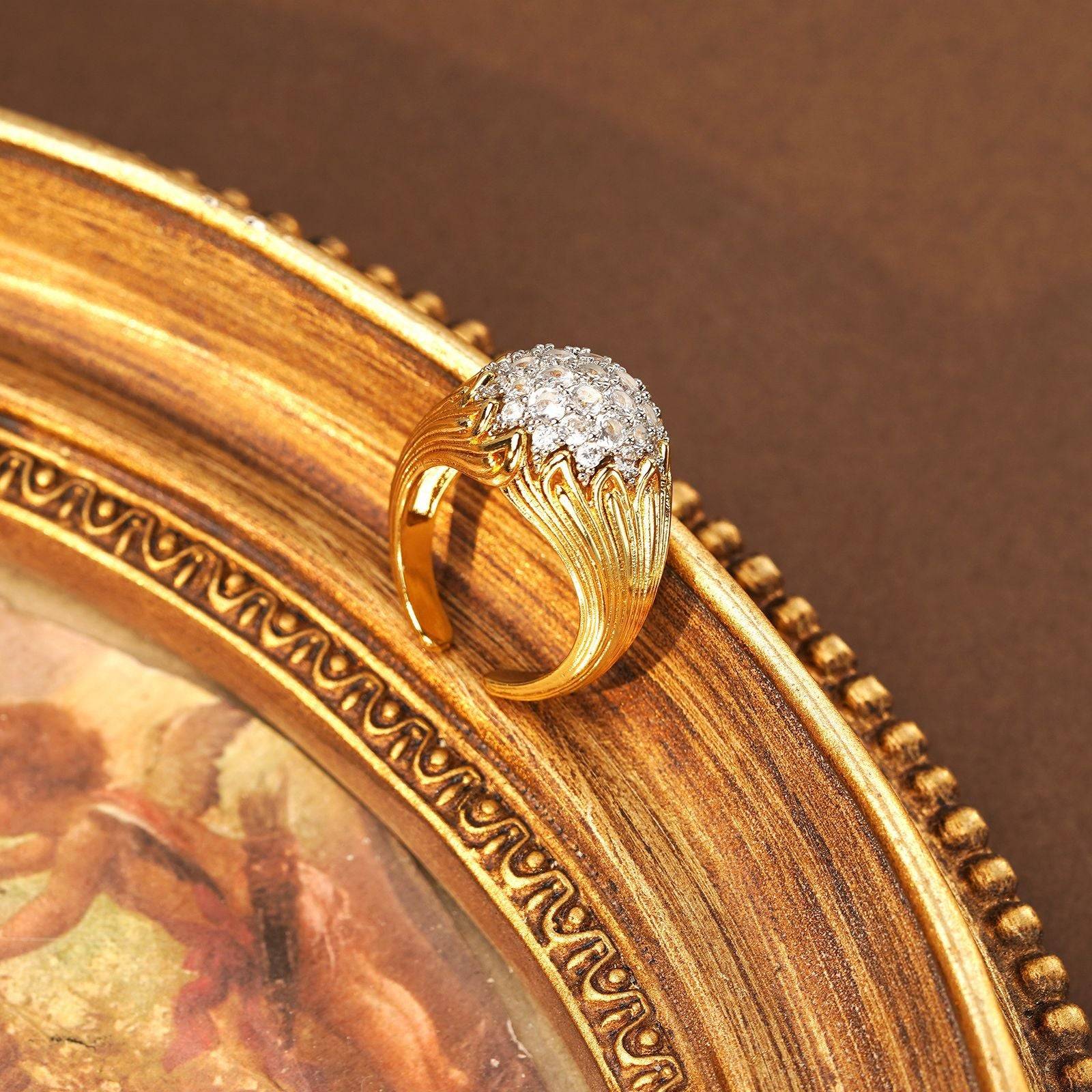Side view of the Regency-inspired gold statement ring showing the ornate carvings.