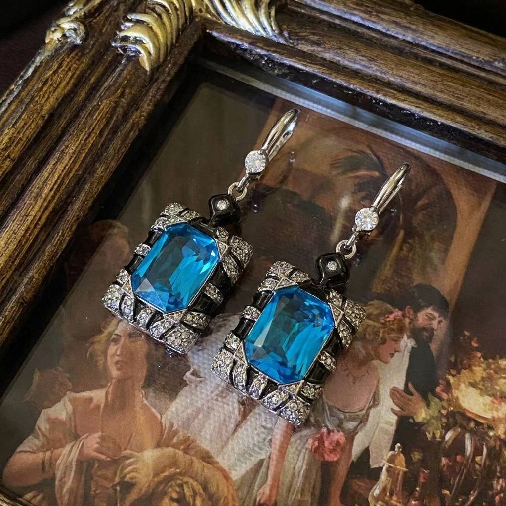 High-definition detail of the royal blue crystal and lustrous pearl on drop earrings.