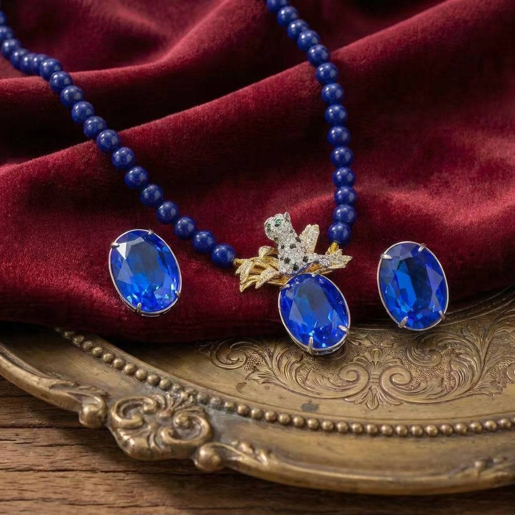 Ever P. sapphire blue jewelry set featuring a necklace and earring set in gold.