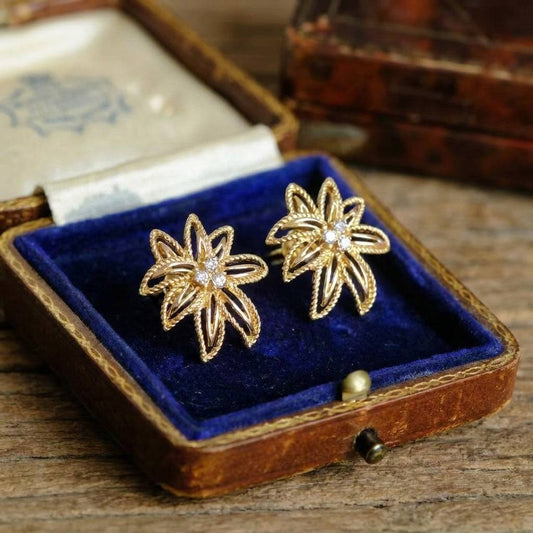 Close-up of the fine floral filigree and textured gold finish on vintage earrings.