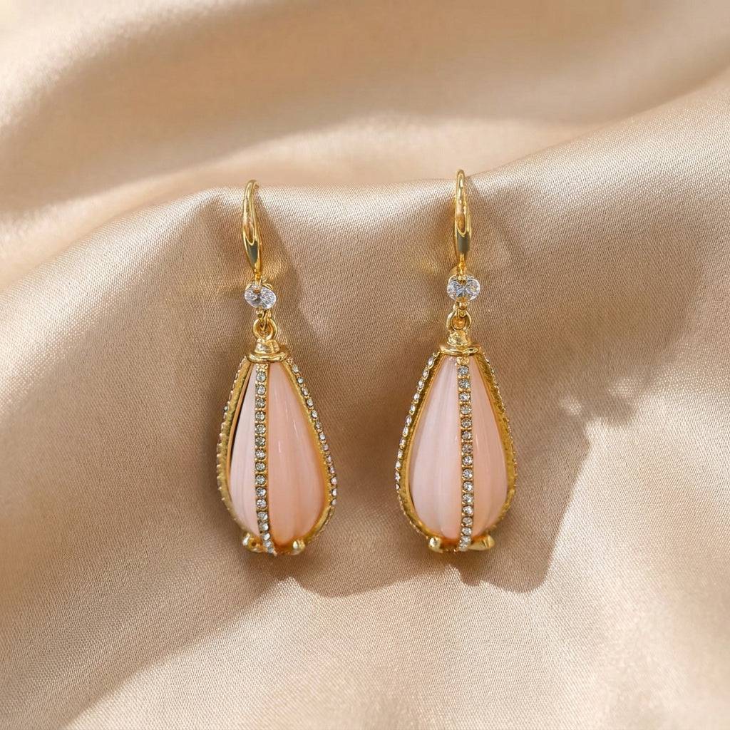 Side perspective showing the 5.1cm length of the vintage pink teardrop earrings in gold.
