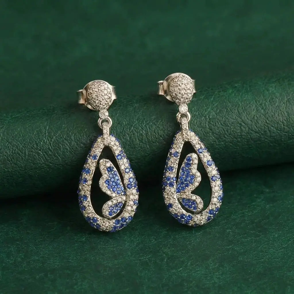 Side view showing the detailed gold plating and blue stone setting on butterfly studs.