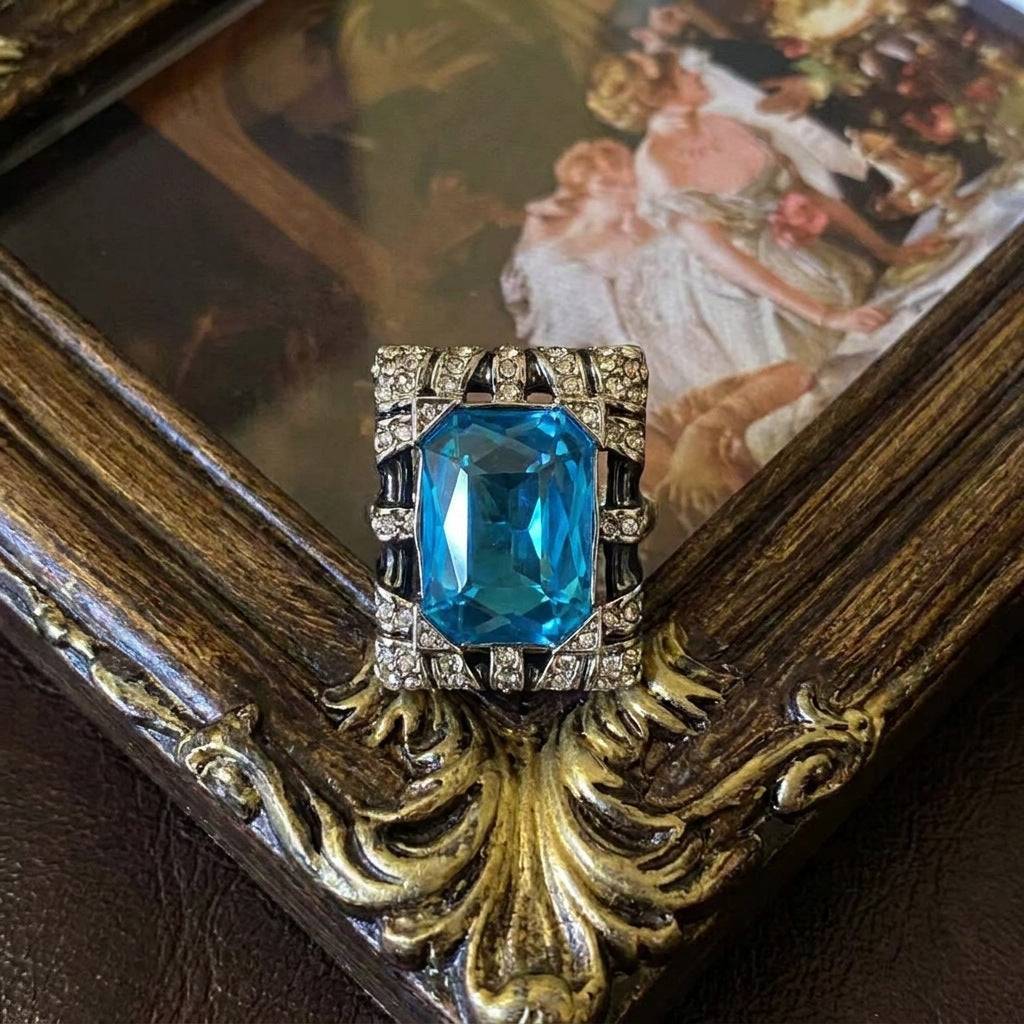 Top view of the Ever P. vintage style pearl ring with a central blue gemstone.