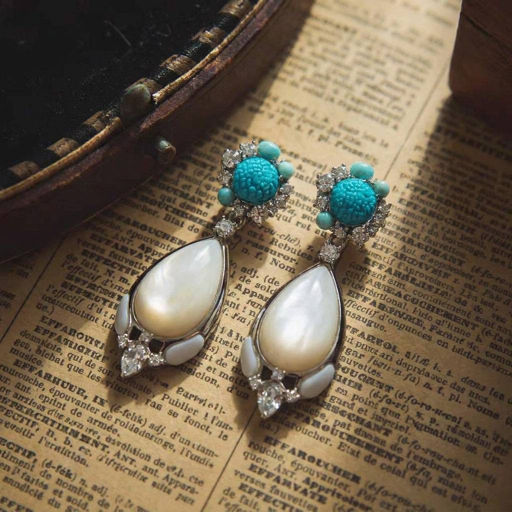 Elegant wedding guest jewelry: white shell teardrop earrings with ornate carvings.