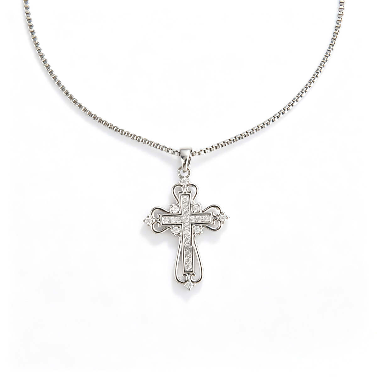 Front view of an ornate filigree cross pendant with pavé cubic zirconia on a box chain.