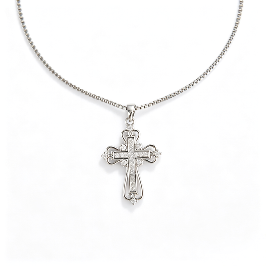 Front view of an ornate filigree cross pendant with pavé cubic zirconia on a box chain.